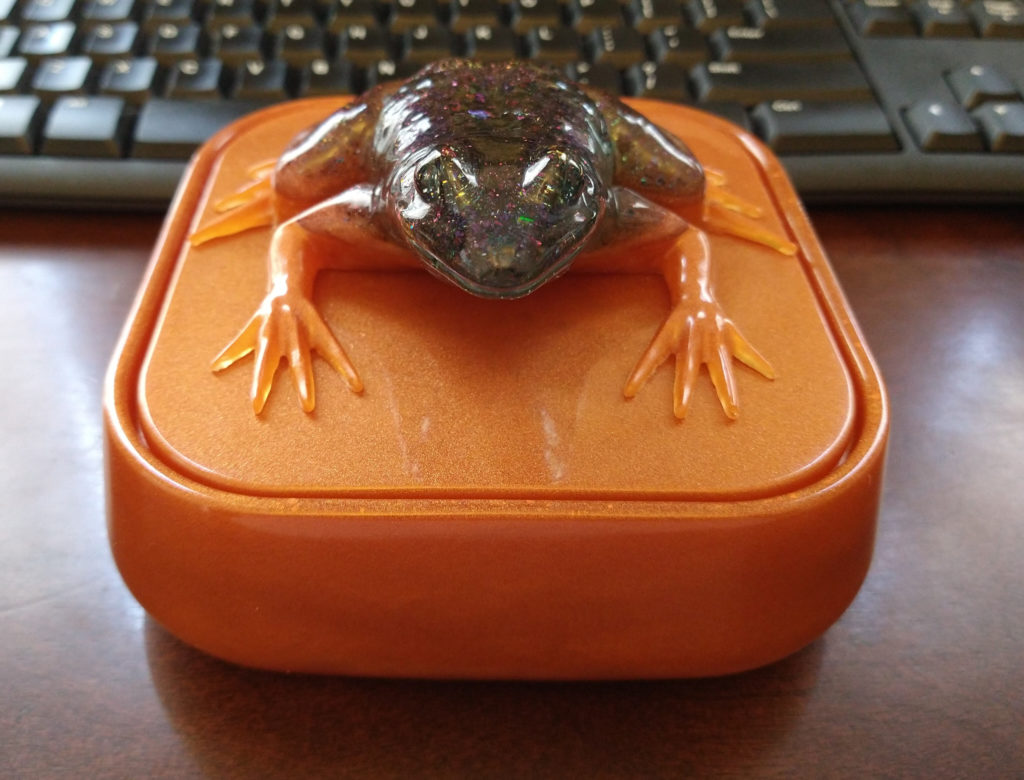 Orange resin box with frog on top.