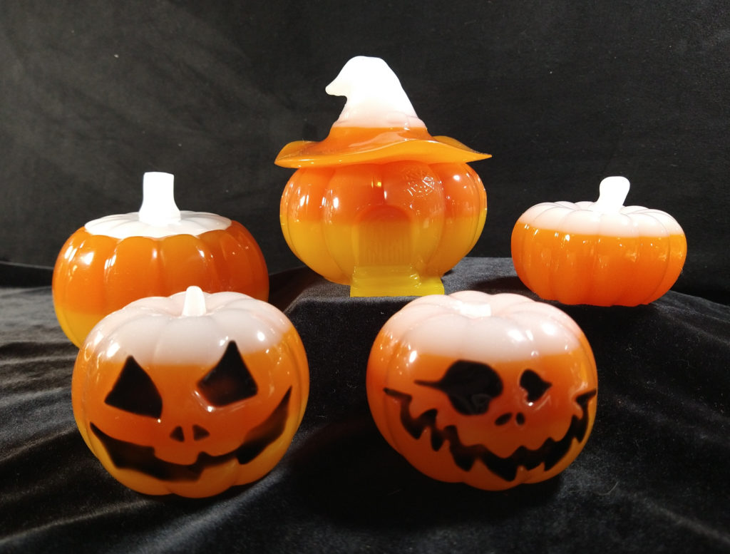 Five resin pumpkins in candy corn colors.
