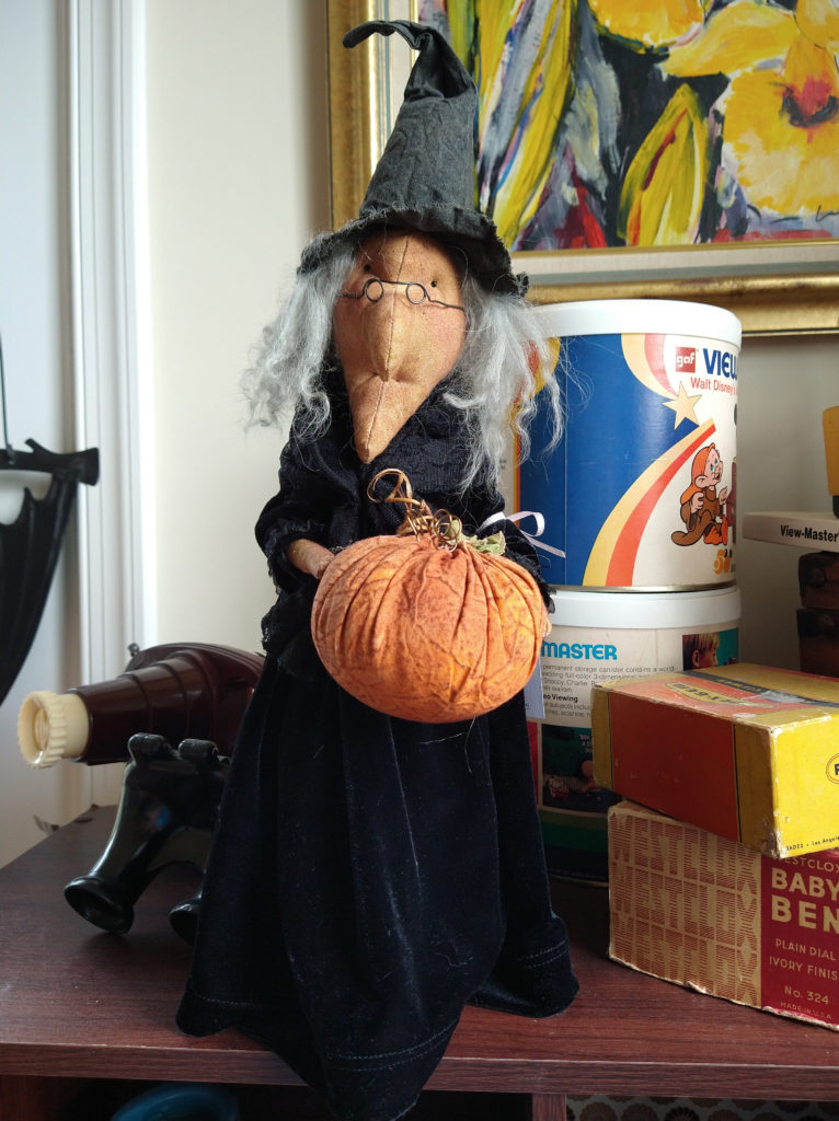 Soft-sculpted witch doll with cloth pumpkin.