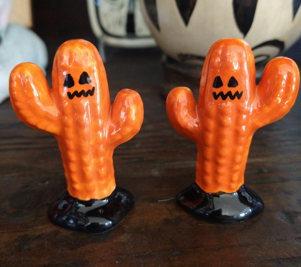 Orange ceramic cacti with jack-o-lantern faces.