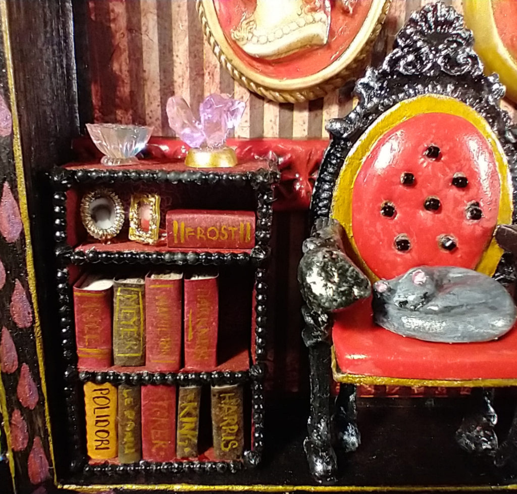 Bookshelf full of vampire books. Chair with sleeping cat.