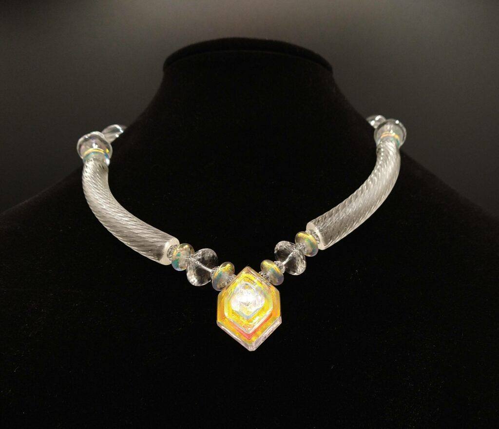 All-glass necklace with spun side pieces and a prismatic center bead.