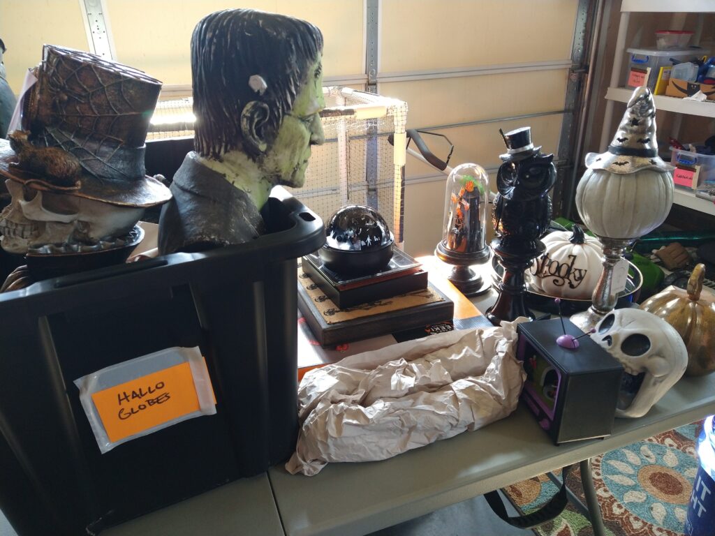 Table piled with all sorts of Halloween decor.