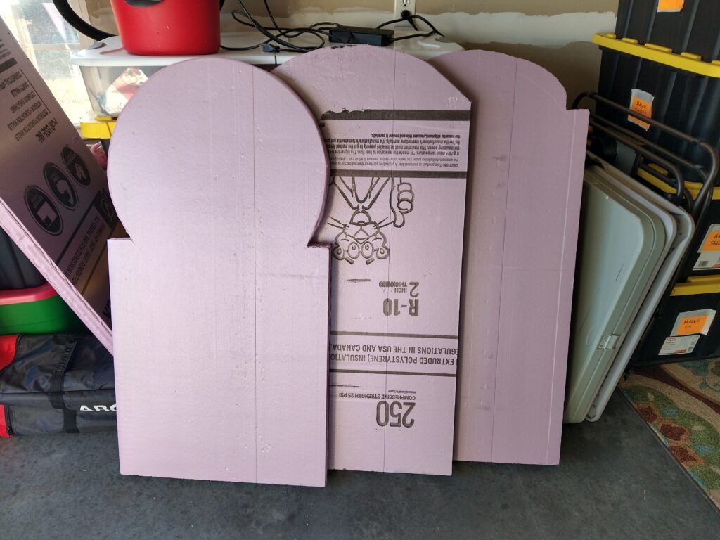 Three unfinished tombstones make of pink insulation board.