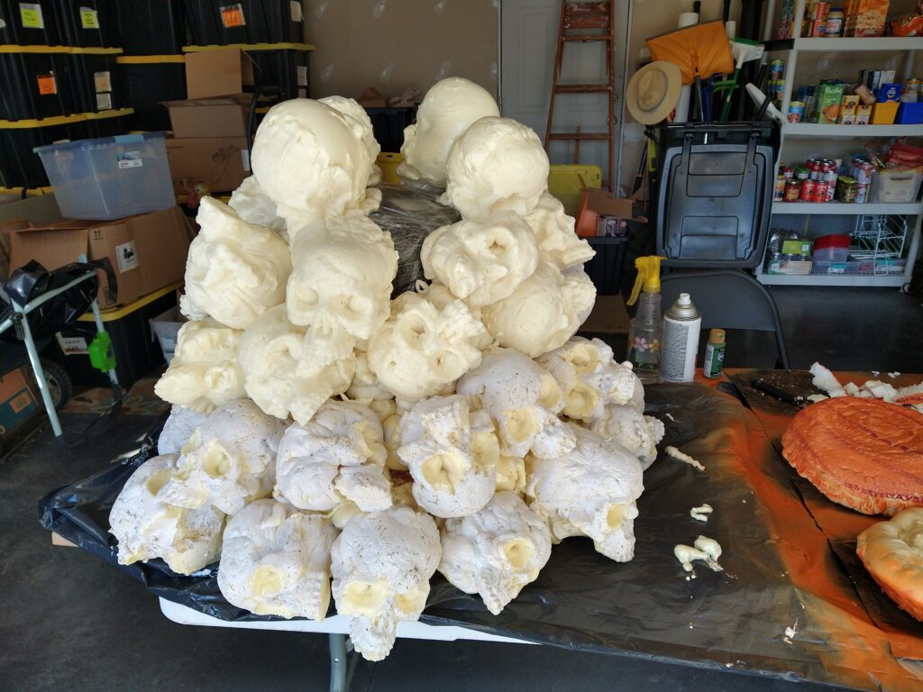 A mound of skulls about five skulls high. It is half painted, and bits are still missing.